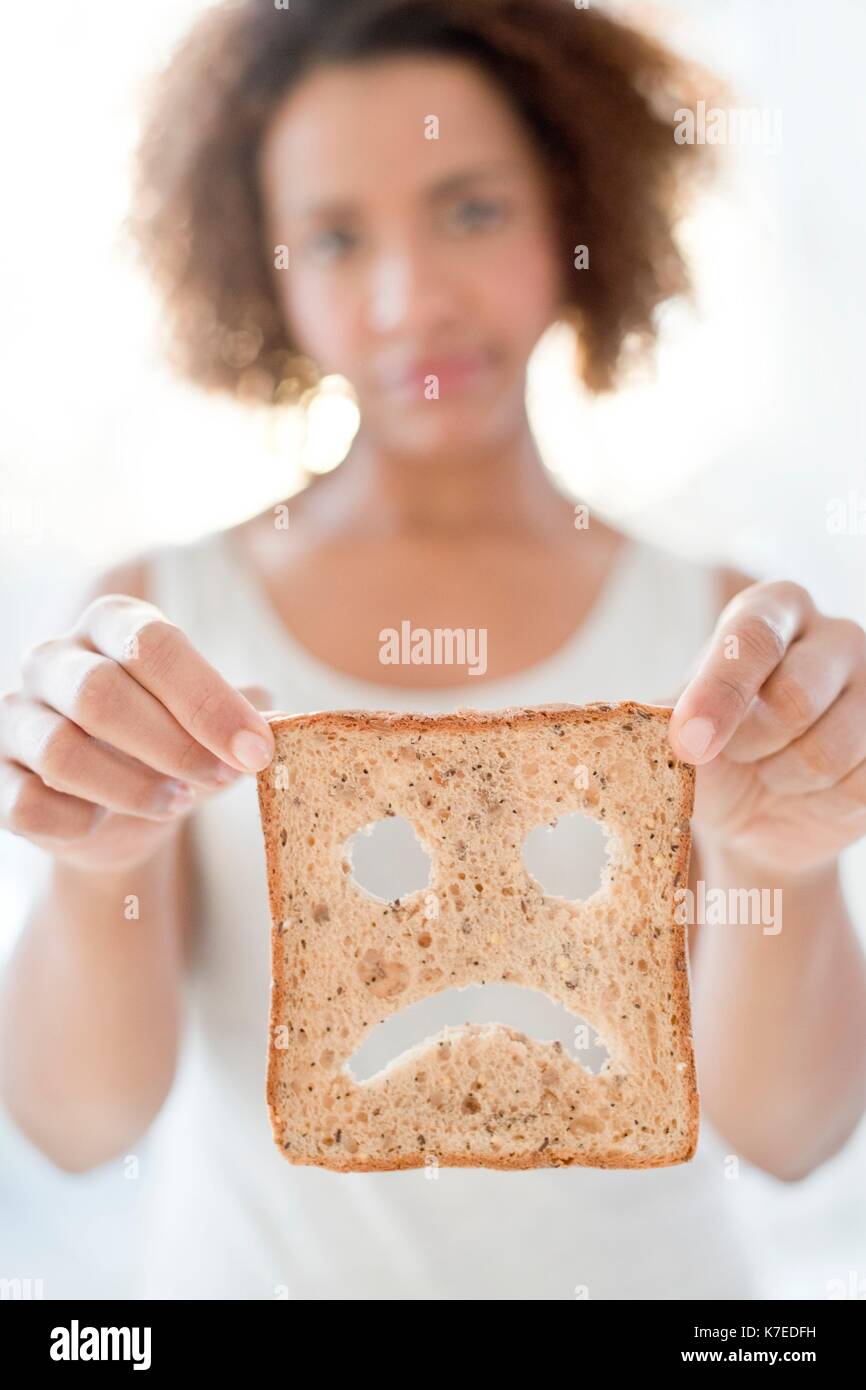 Mid adult woman holding bread with sad face. Stock Photo