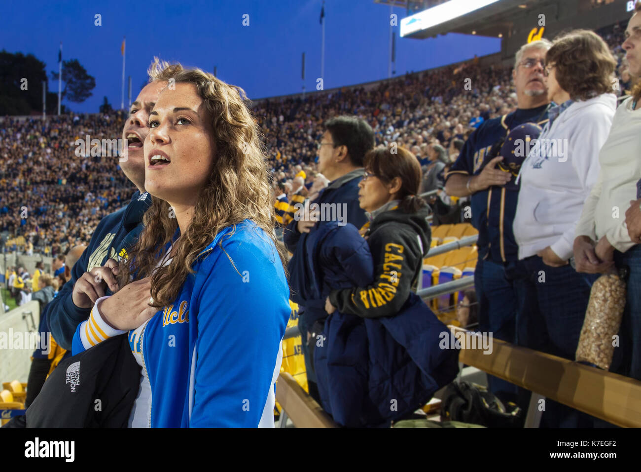 Berkeley, California-Oct. 6, 2012:People at a night football game sing the National Anthem before it starts. University of California Berkeley vs UCLA Stock Photo