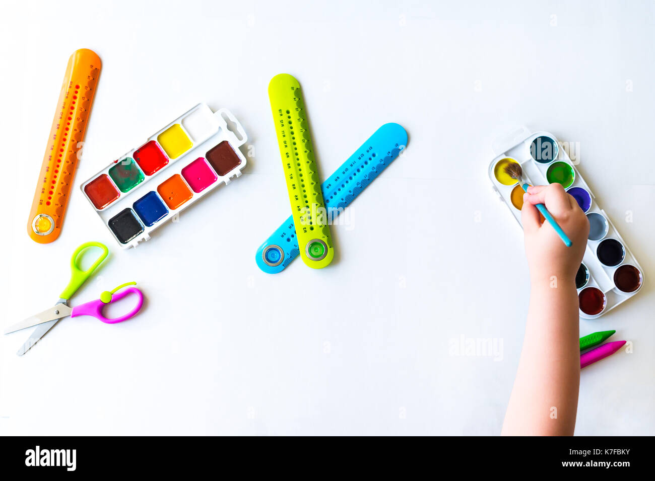 The child holds the brush over the palette Stock Photo Alamy
