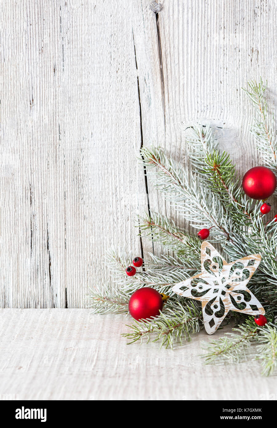Fir branch with Christmas decorations on white rustic wooden background ...