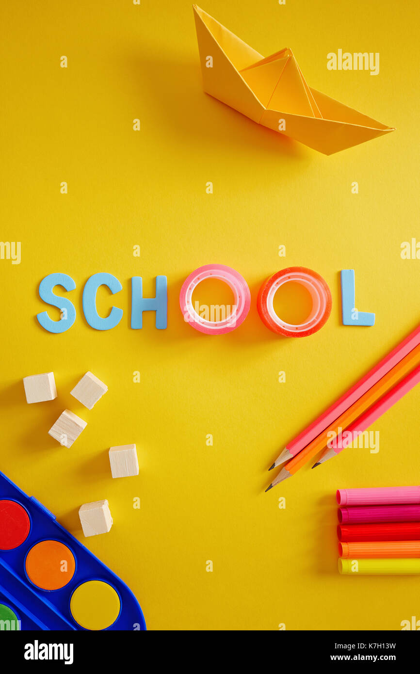 Back to school supplies and letters on yellow background. Stock Photo