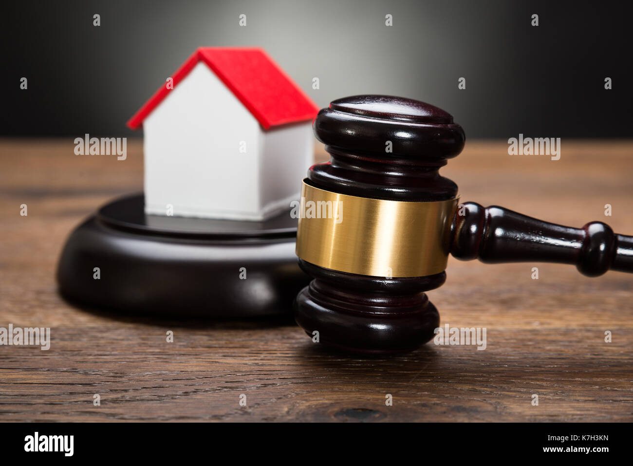 Close-up Of House Model With Gavel On Wooden Table Stock Photo