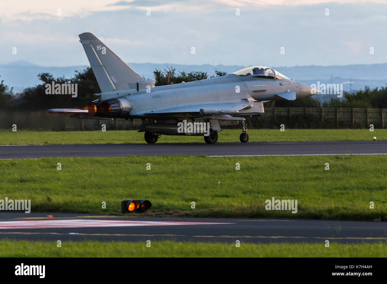 The afterburners on a Royal Air Force Typhoon FGR4 lights up the runway at Liverpool John Lennon airport during an autumn evening in 2017. Stock Photo