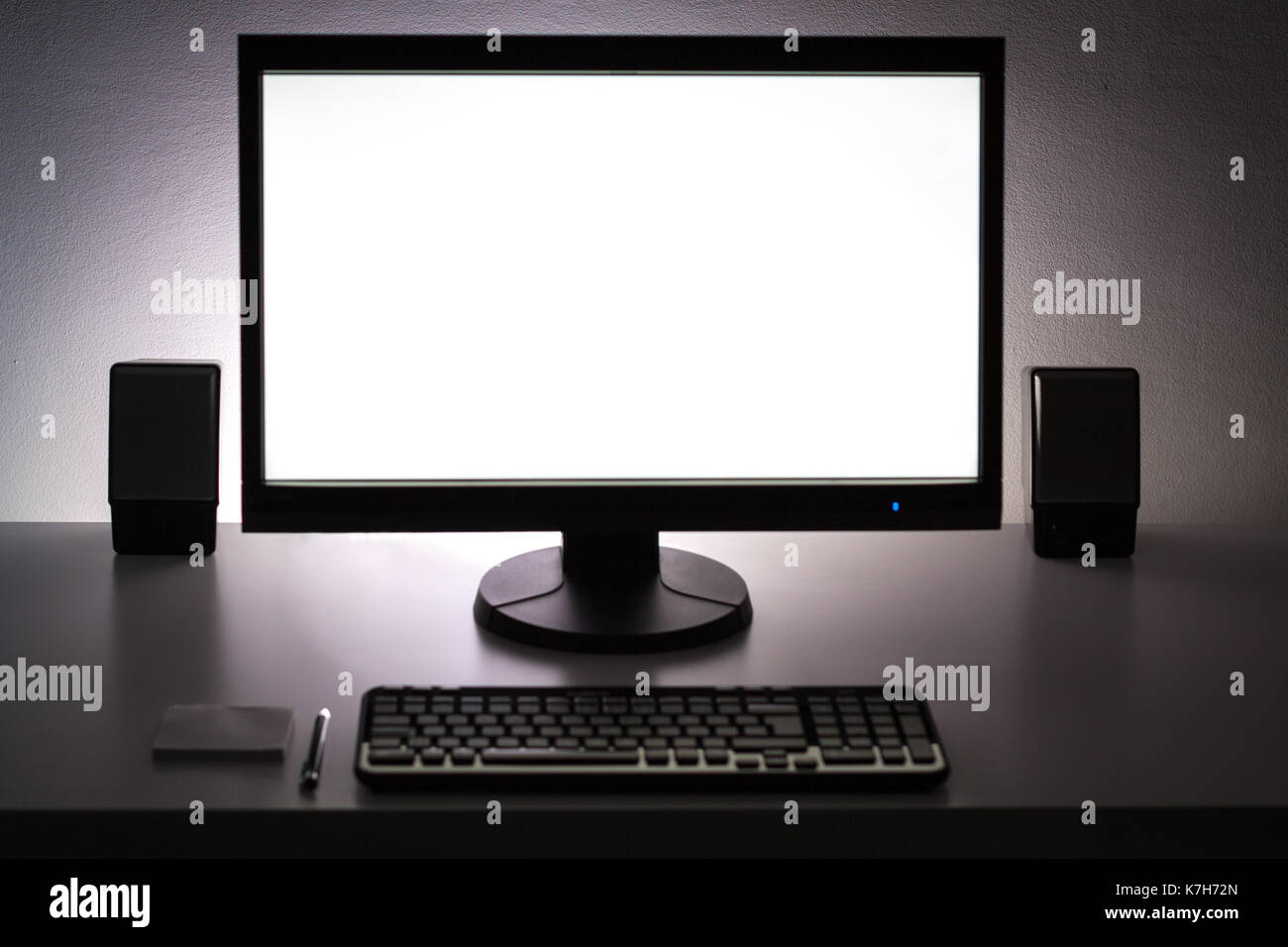 Blank white pc monitor on desktop in organized workplace. Stock Photo