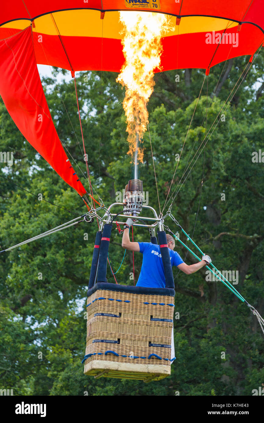 Longleat, Wiltshire UK. 15th September 2017. A mixed day of weather doesn't deter visitors enjoying the Sky Safari hot air balloons at Longleat. Man in hot air balloon basket tethered balloon in air with gas burners and flames. Credit: Carolyn Jenkins/Alamy Live News Stock Photo