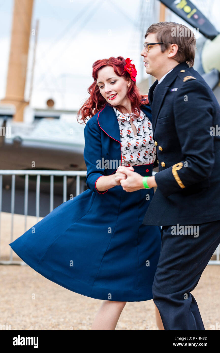 Young couple dancing in 1950s clothing. Woman in blue skirt and jacket man in Royal Navy officer s uniform during the Salute to the 40 s popular weekend at Chatham Historic Dockyard Stock Photo
