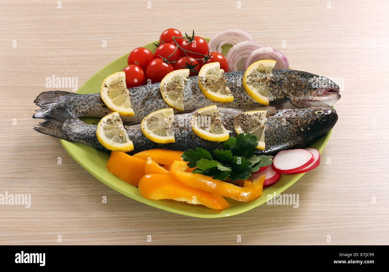 prepared trout with lemon and salad on plate Stock Photo