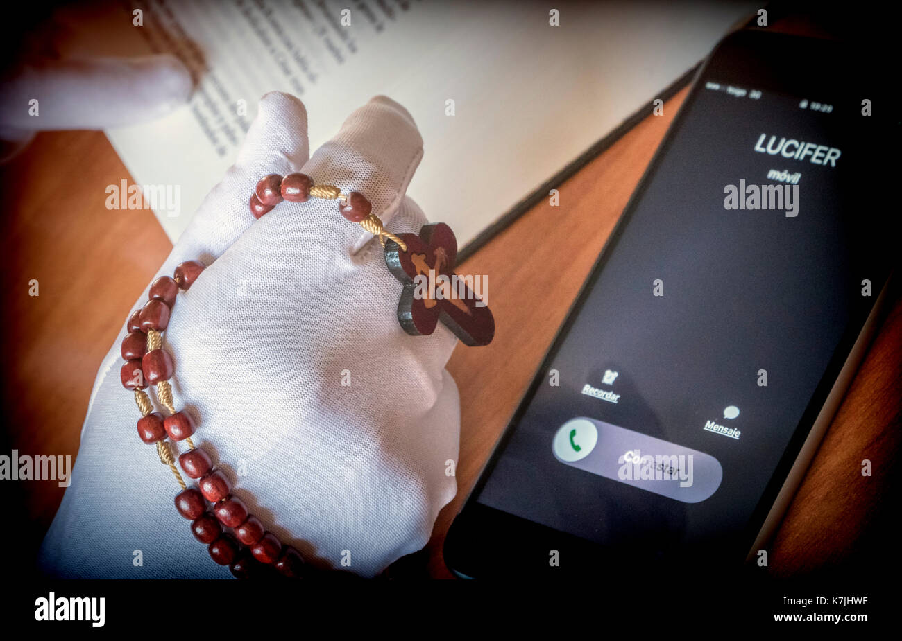 Lucifer calling a woman praying with a rosary Stock Photo