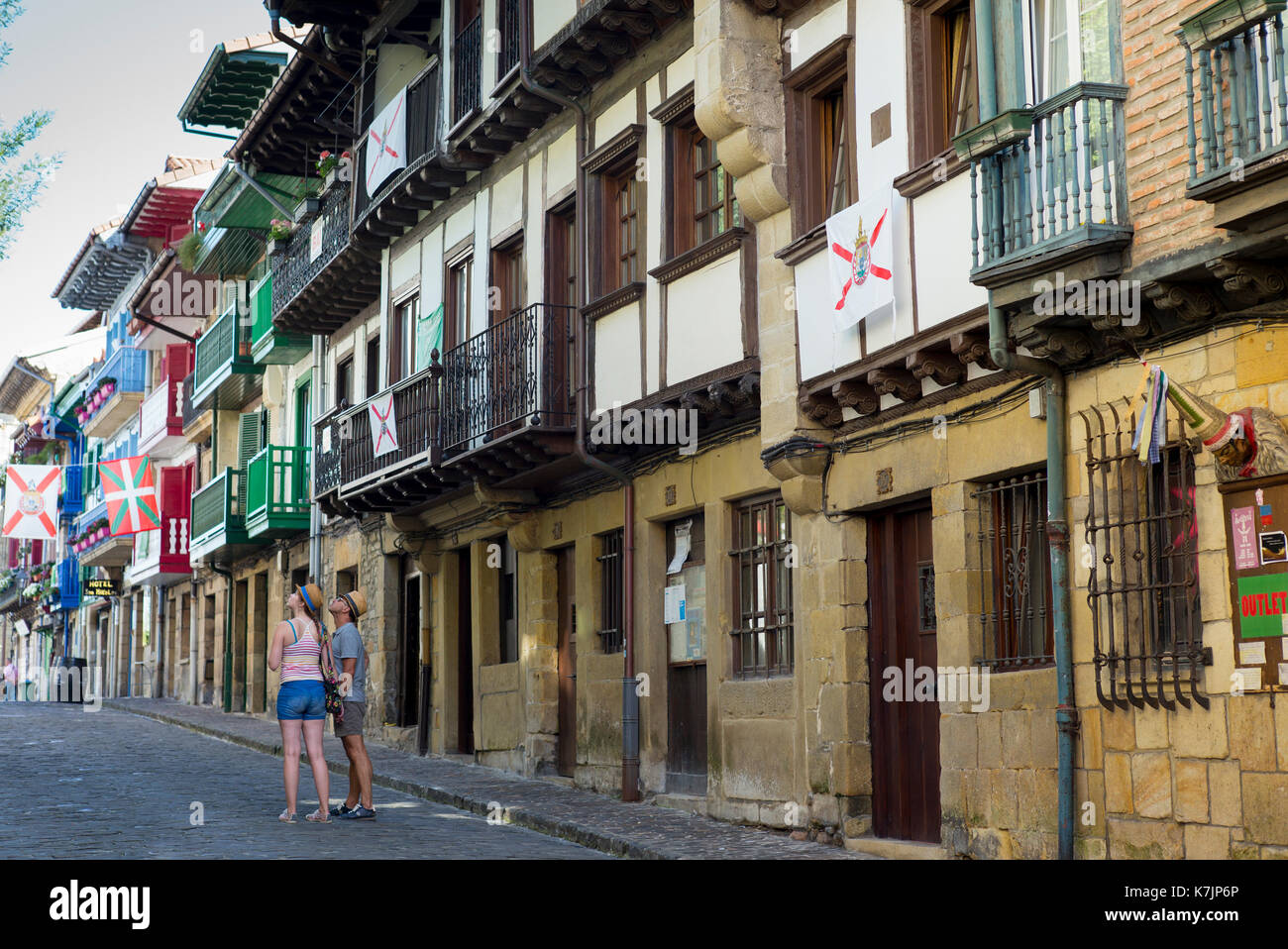 Tourists couple in street scene in alleyway of old town Hondarribia, in Basque Country, Spain Stock Photo