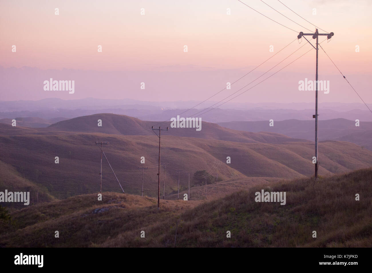 Line of power pole during the misty morning on Wairinding Hill on East Sumba, Indonesia Stock Photo