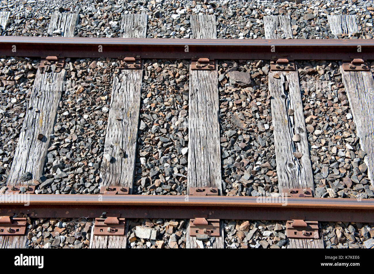 Old timber sleepers supporting steel rails on a little used part of the railway system Stock Photo