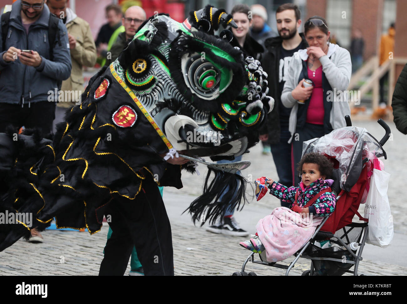 Ayana Kenny, 2, watches a Chinese dragon performance during the BlueFire street fest in Smithfield, Dublin. Stock Photo