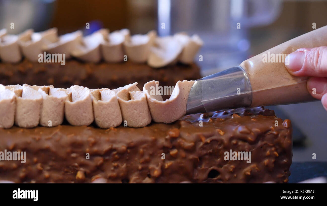 Closeup of squeezing filling of salted caramel cream from confectionery bag  into candy molds for preparing handmade chocolate pralines Stock Photo -  Alamy