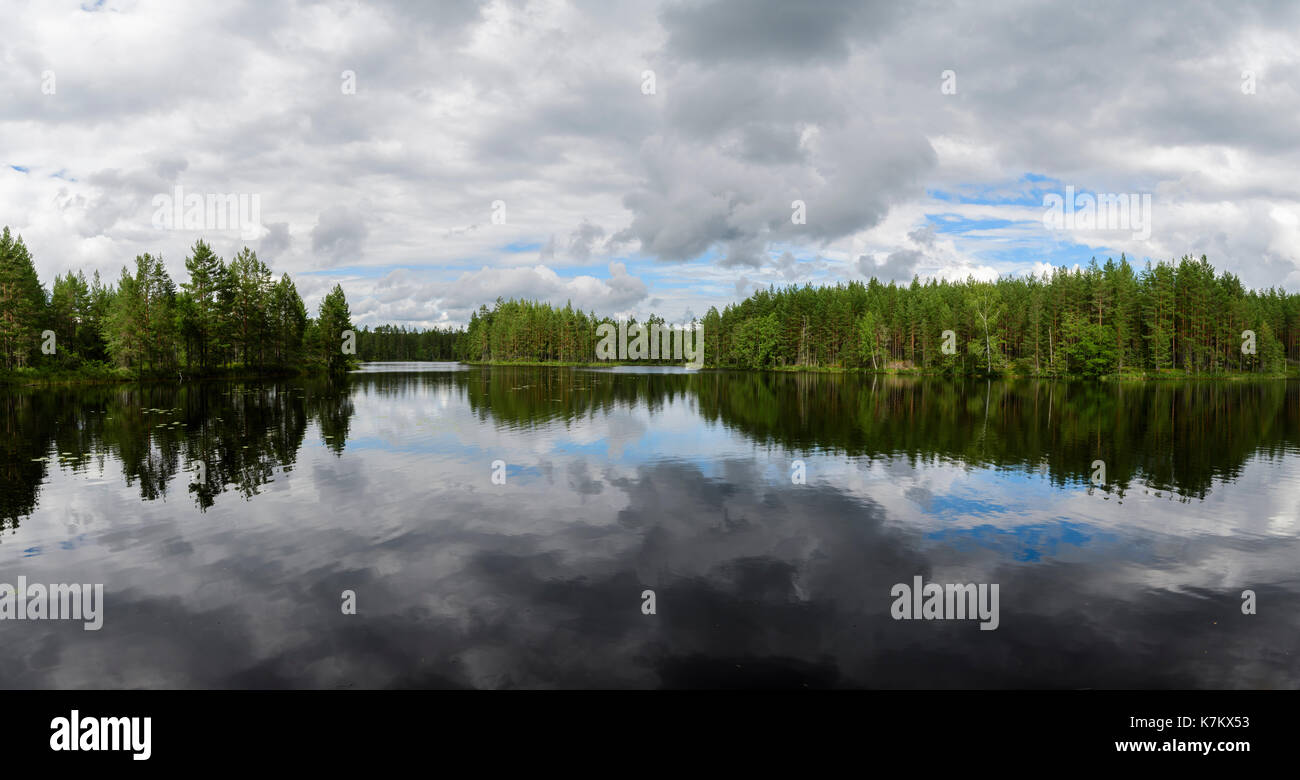 Lake in Swedish forest with clouds reflecting in the water Stock Photo