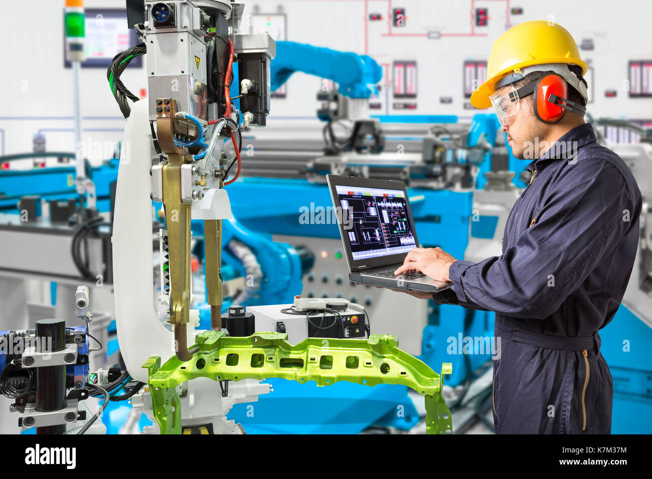 Engineer use computer checking industry robotic in factory Stock 