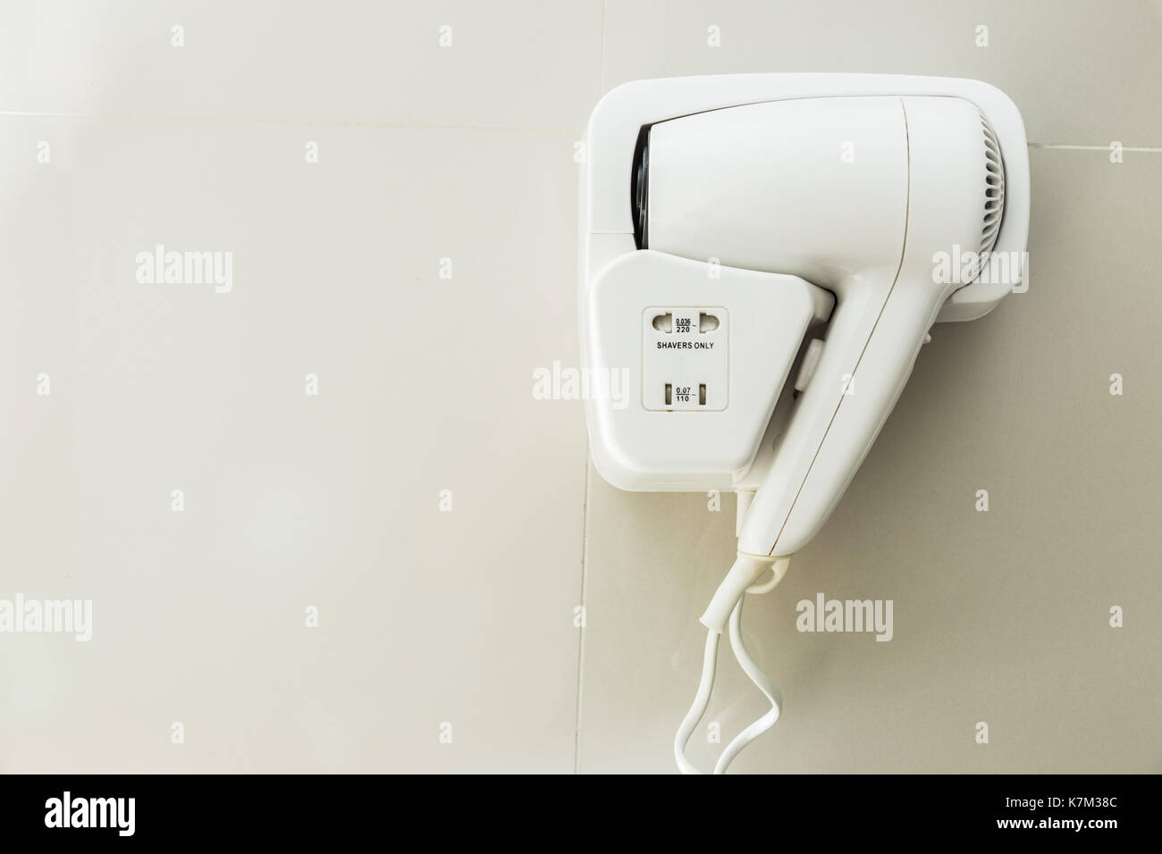 hotel hair dryer hanging on the bathroom wall Stock Photo Alamy