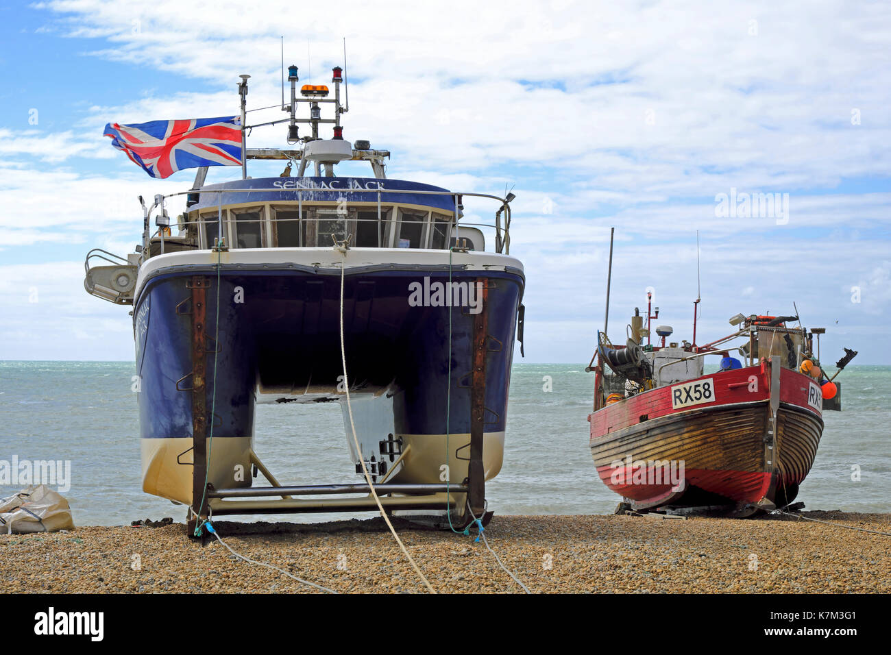 The old traditional clinker built and the modern catamaran fishing boats on Hastings Stade Beach, East Sussex, England, UK Stock Photo