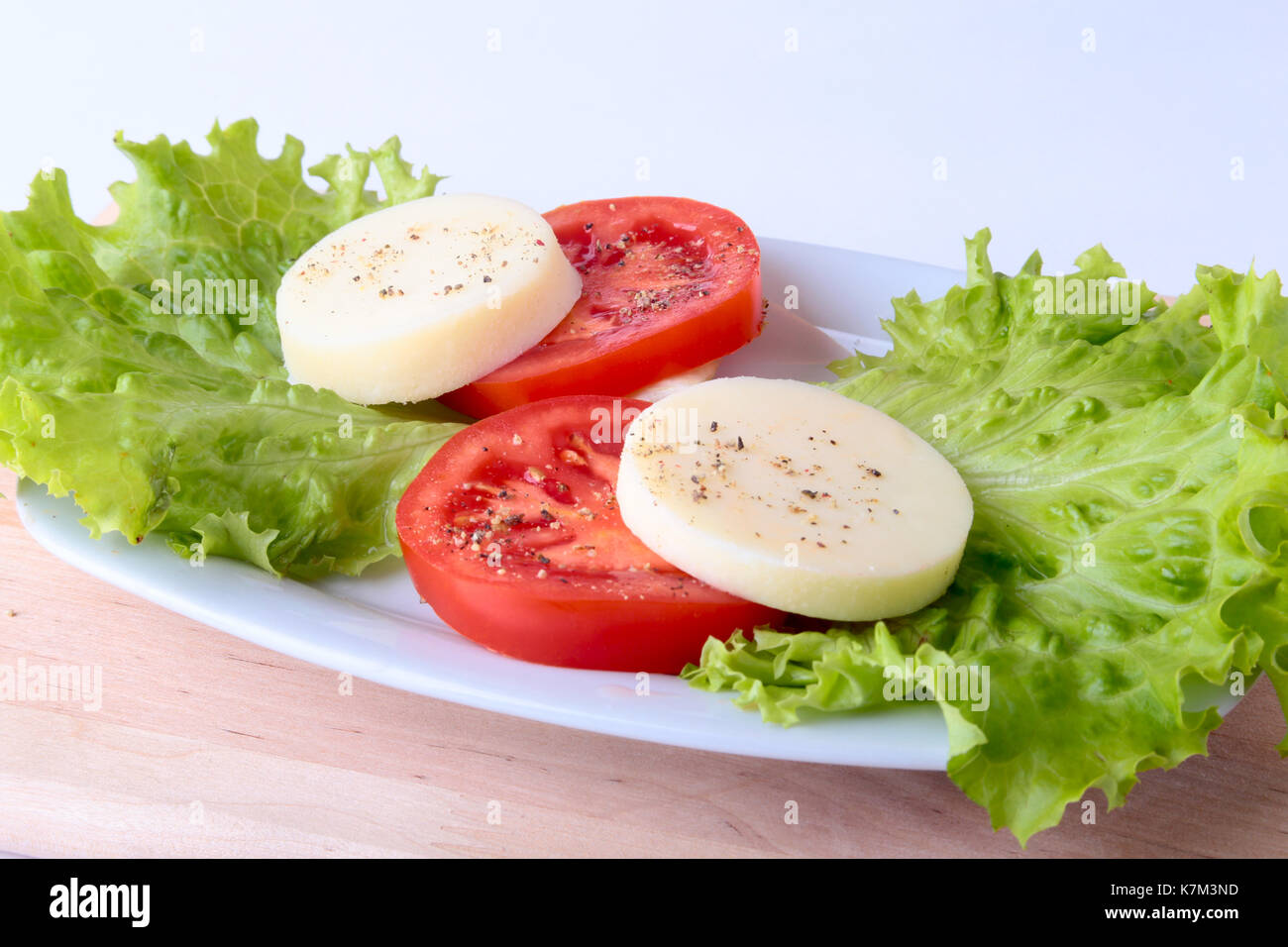 Portion of Mozzarella with Tomatoes, lettuce leaf and Balsamic dressing