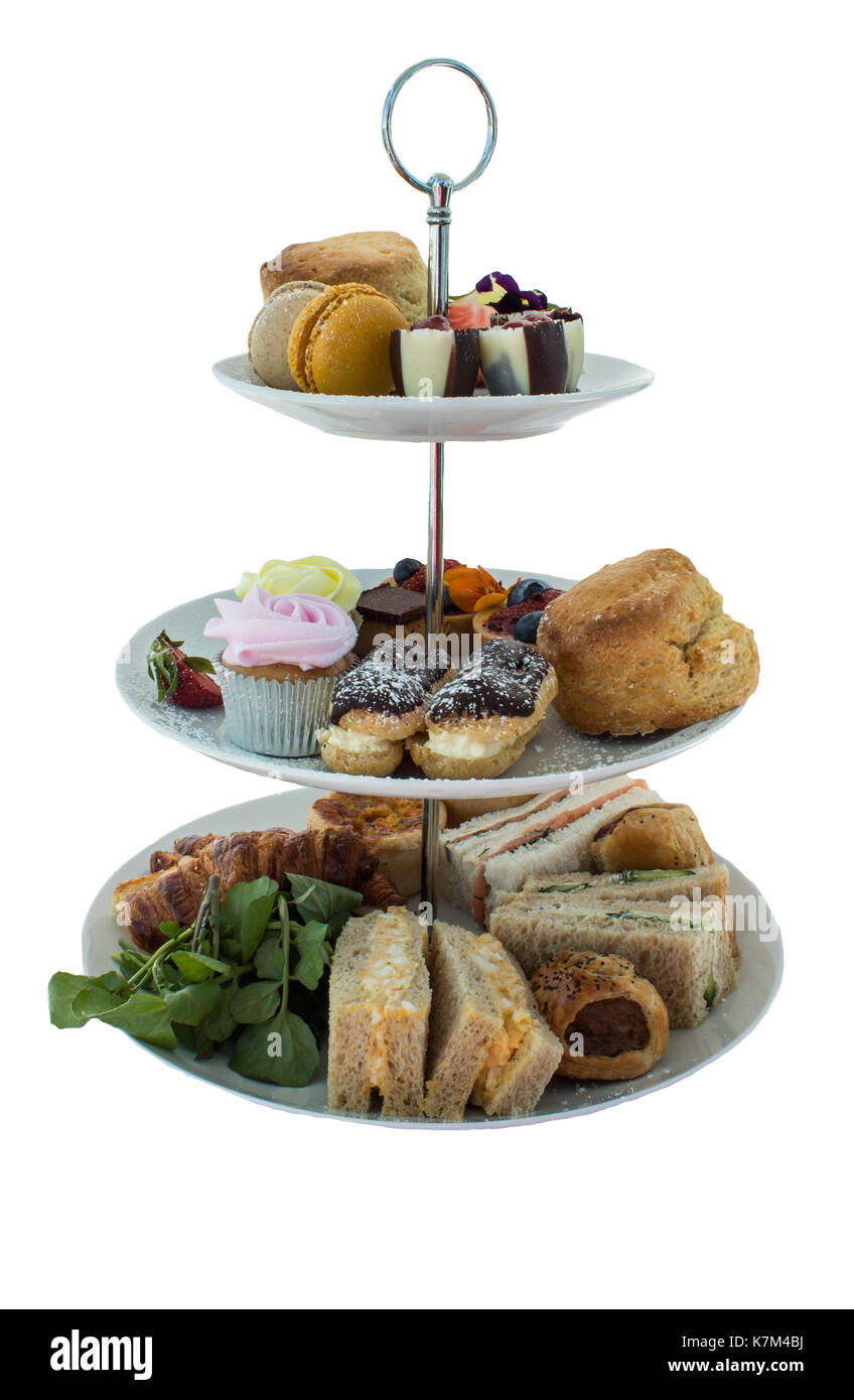 Assortment of high tea delicacies including sandwiches, scones, pies, sweet desserts isolated Stock Photo