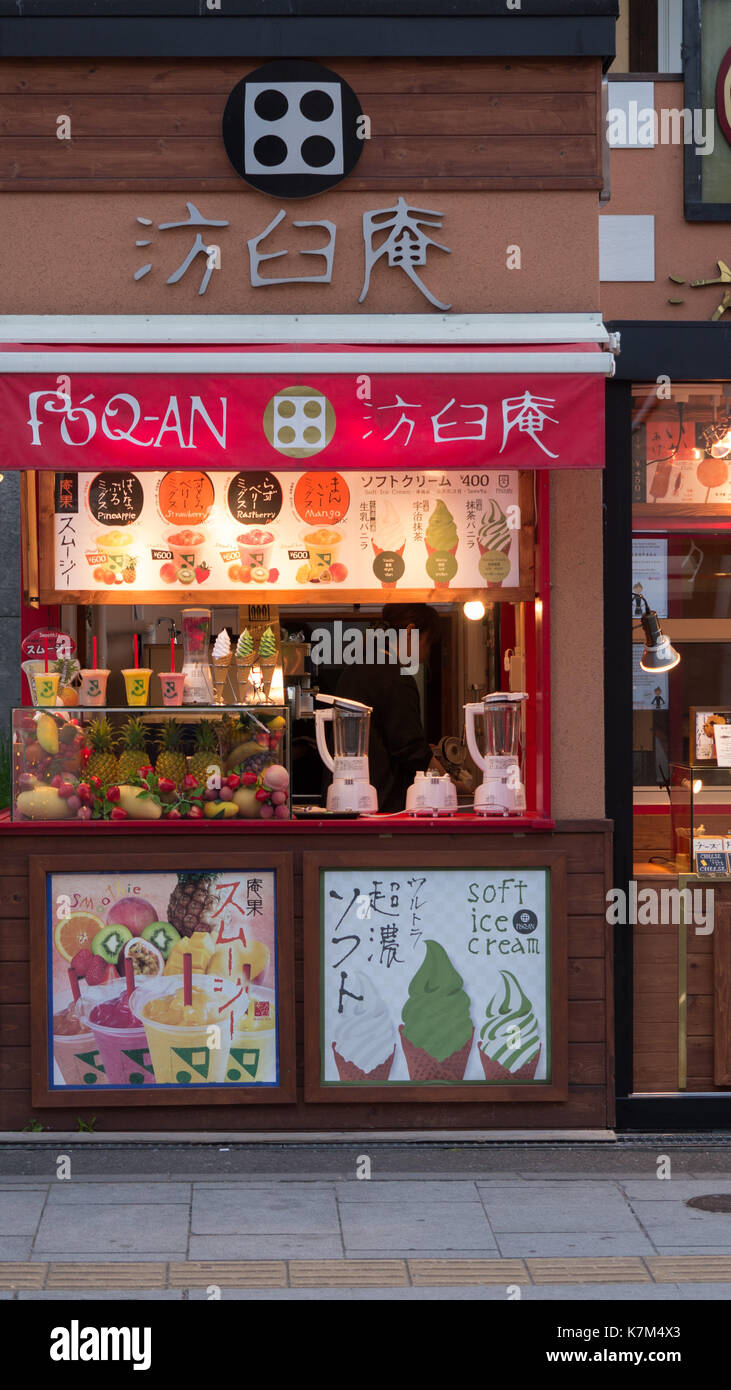 Evening shot of japanese ice cream sidewalk shop with lit signs, ice