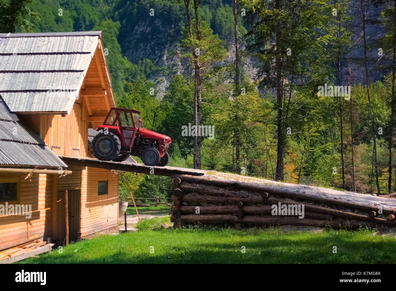 Rustic Old Red Tractor On Ramp Of Wooden Barn Woods And Mountains