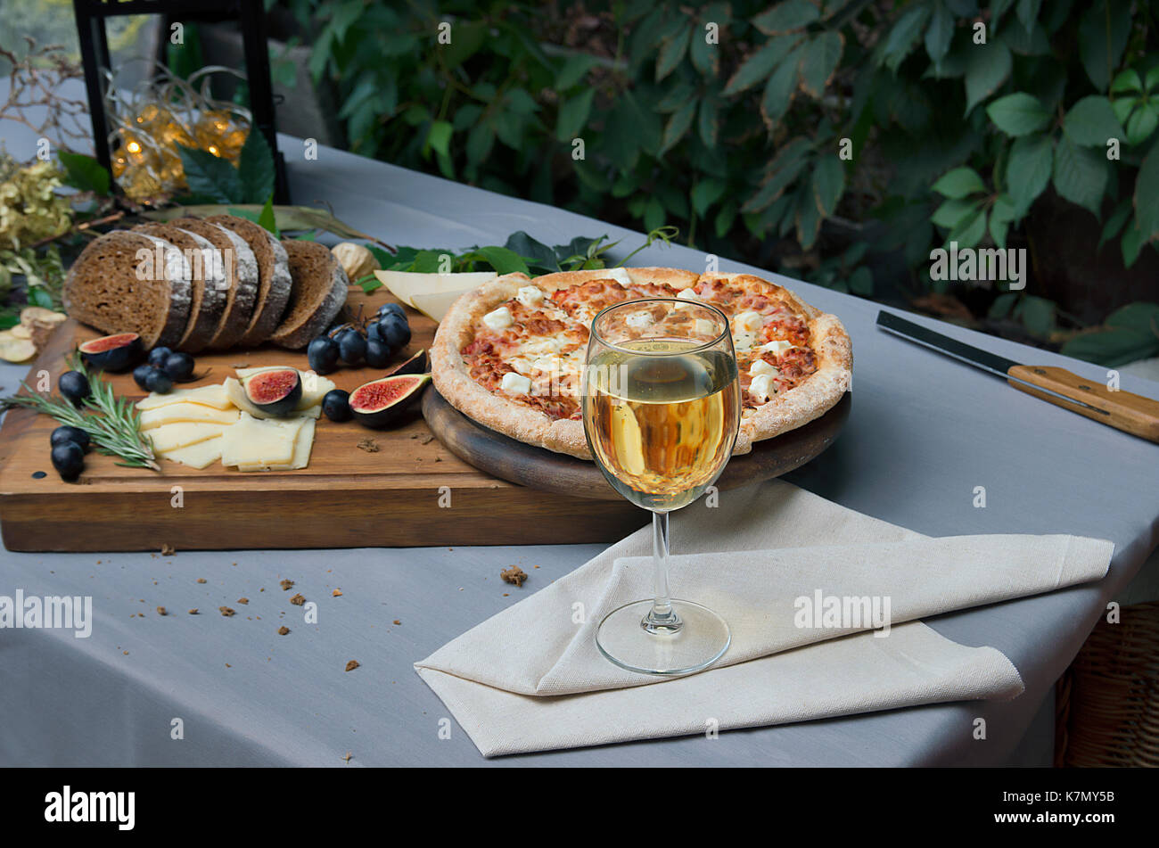 Pizza on board, cheese and leafs on the table Stock Photo
