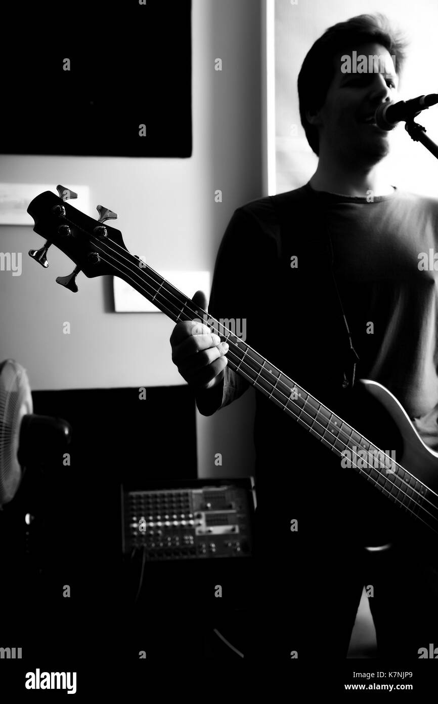 Black and white Portrait of a Rock singer playing bass in the rehearsal