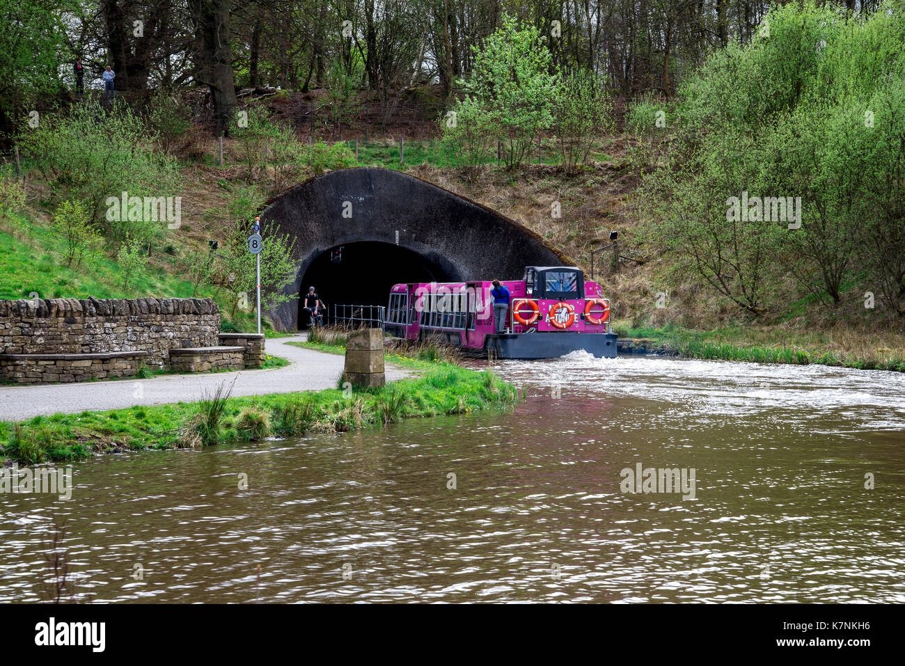 A tourist ferry boat enters a tunnel from Falkirk Wheel boat lift to Union Canal locks on the other side, central Scotland Stock Photo
