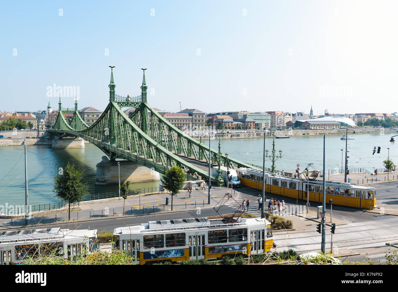 The Liberty Bridge in Budapest, Hungary with some old trams in the foreground passing by. Stock Photo