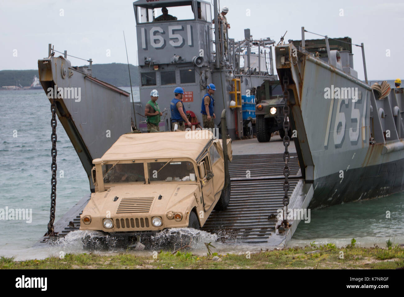 A Humvee drives off of a landing craf Stock Photo