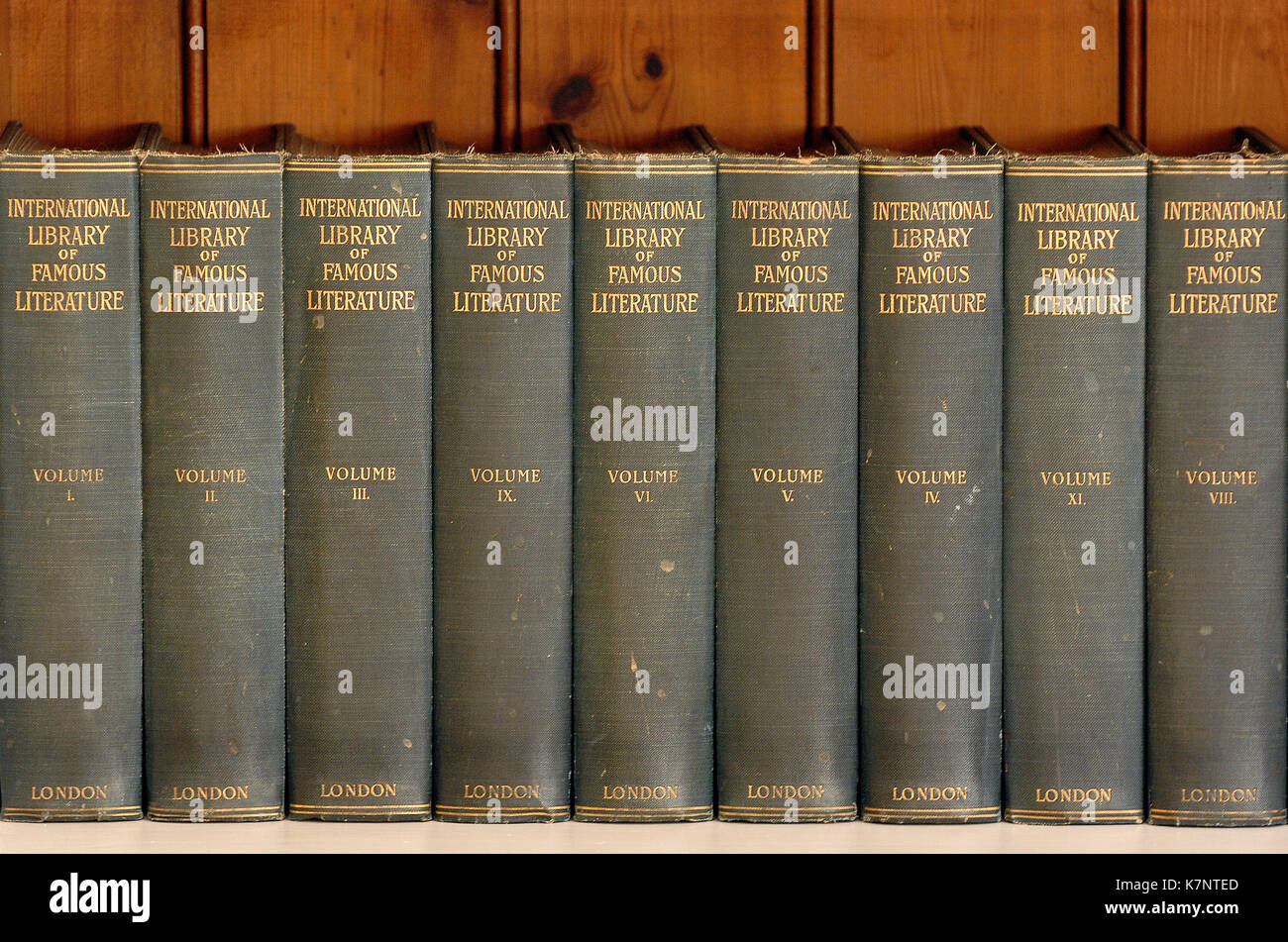 vintage or antique books stored on a shelf or book shelves in a library in a home. Stock Photo
