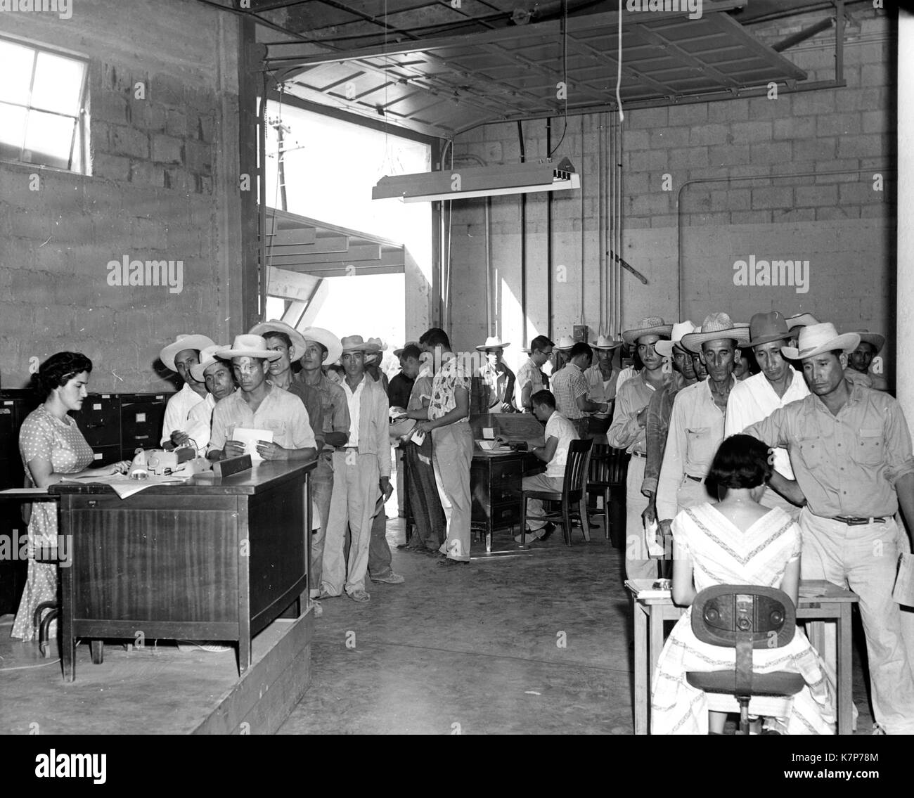 Clerks fill out registration forms for Braceros seeking employment as temporary farm laborers in the United States, 01/01/1957. Stock Photo
