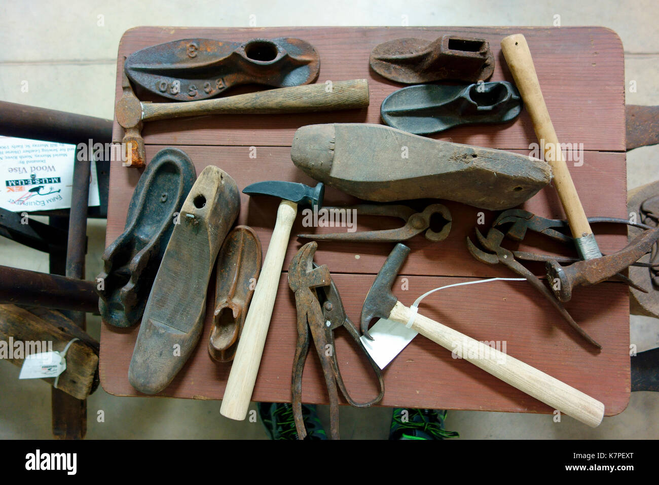 A display of antique shoemaker's or cobbler's tools on a table Stock Photo