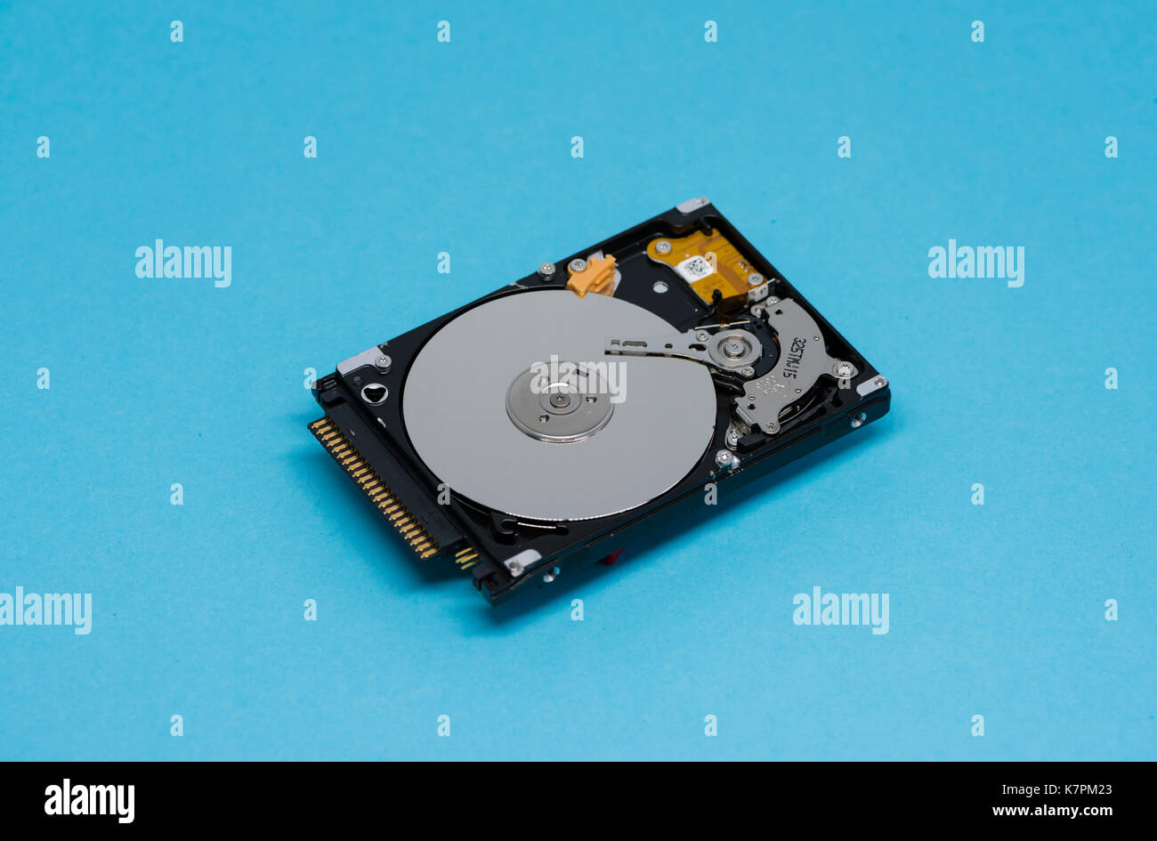 Close-up of an opened computer hard drive disk on blue colored background. Stock Photo