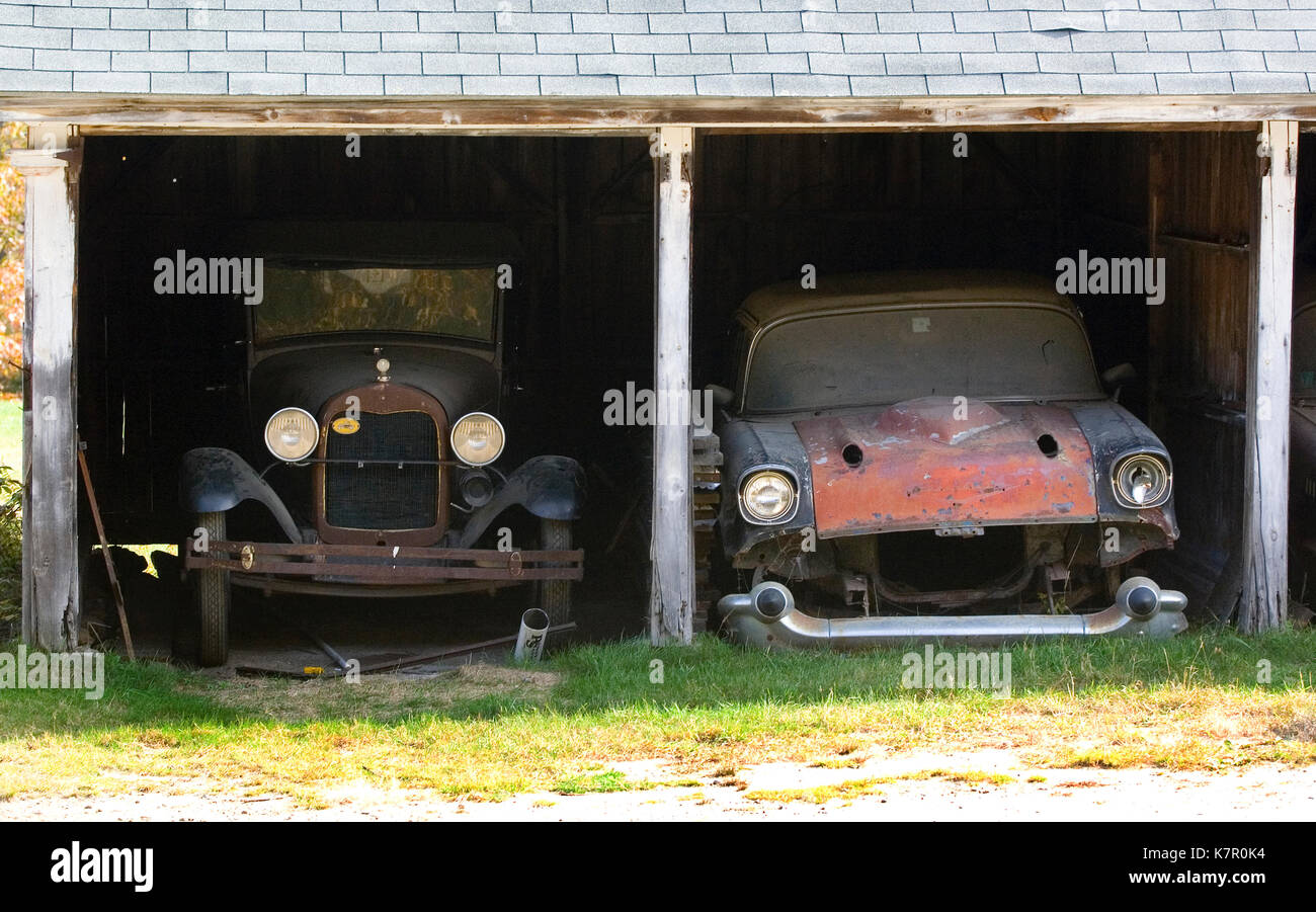 Two antique vehicles in an old barn in Campton, New Hampshire Stock Photo