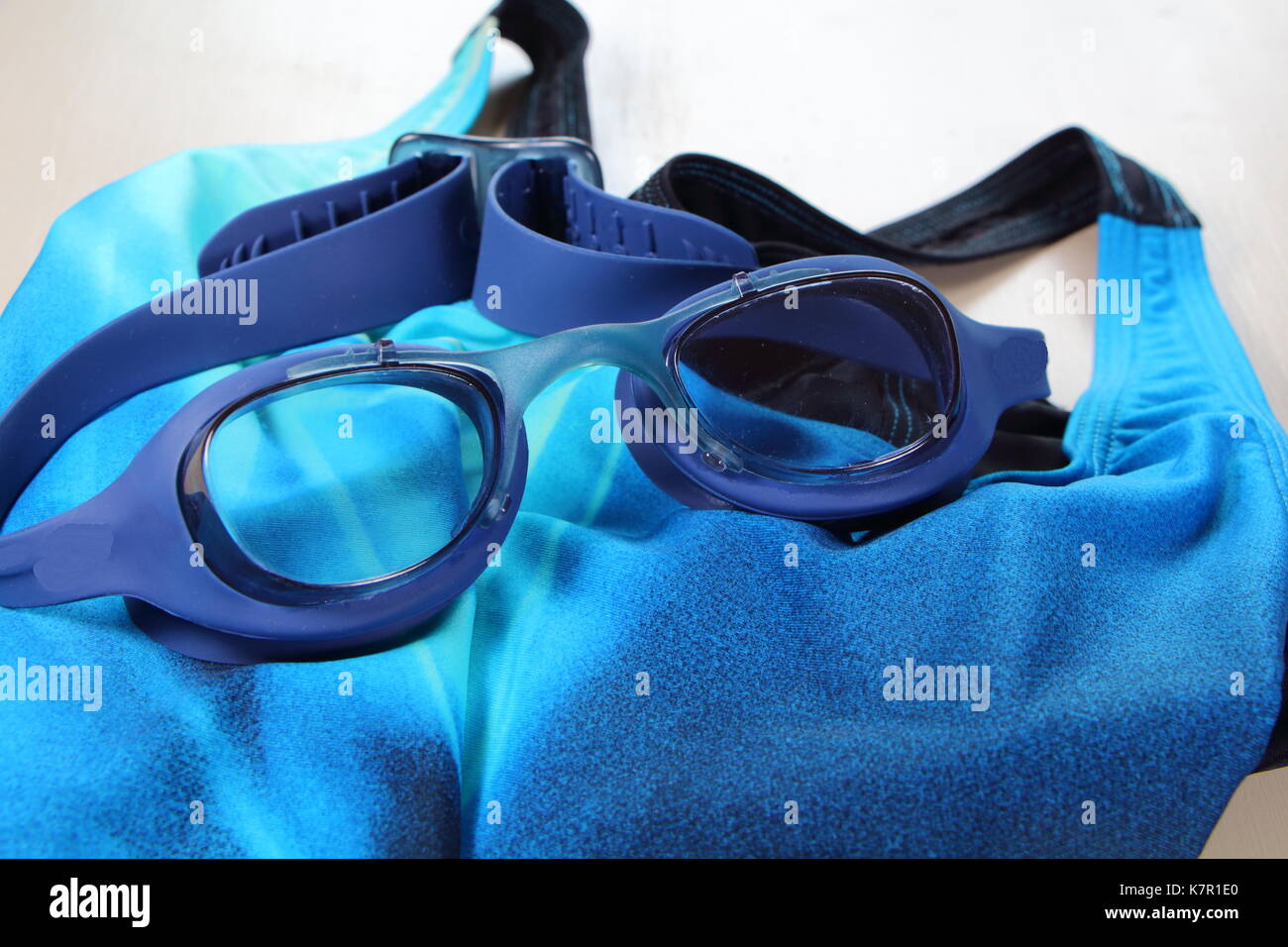 Blue swimming goggles and blue swimsuit for bathing in swimming pool Stock Photo