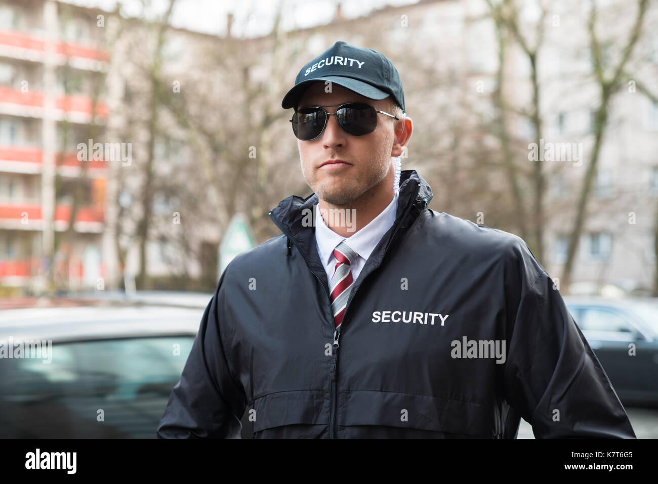 Portrait Of Young Security Guard Wearing Black Uniform And Glasses Stock Photo