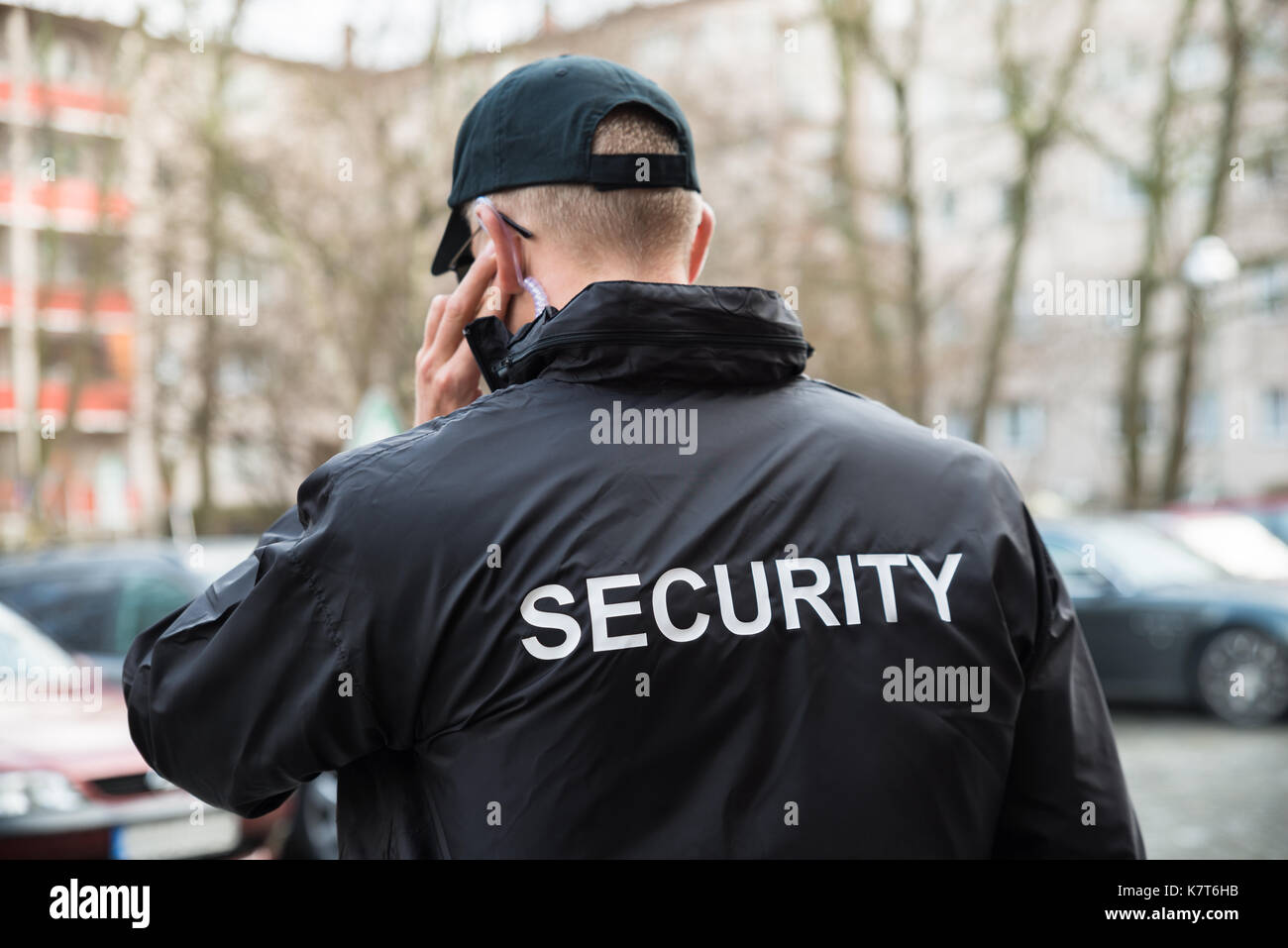 Security Guard In Black Uniform Listening With Earpiece Stock Photo