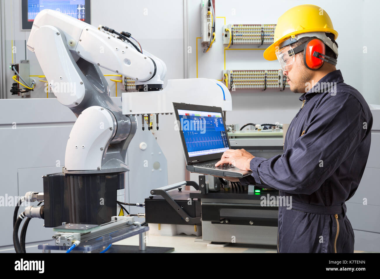 Engineer using laptop computer for maintenance automatic robotic hand machine tool in smart factory, Industry 4.0 concept Stock Photo