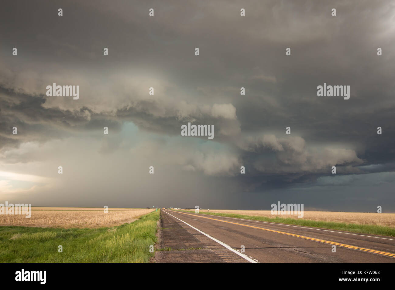 A powerful supercell thunderstorm looms over the highway in eastern Colorado. Stock Photo