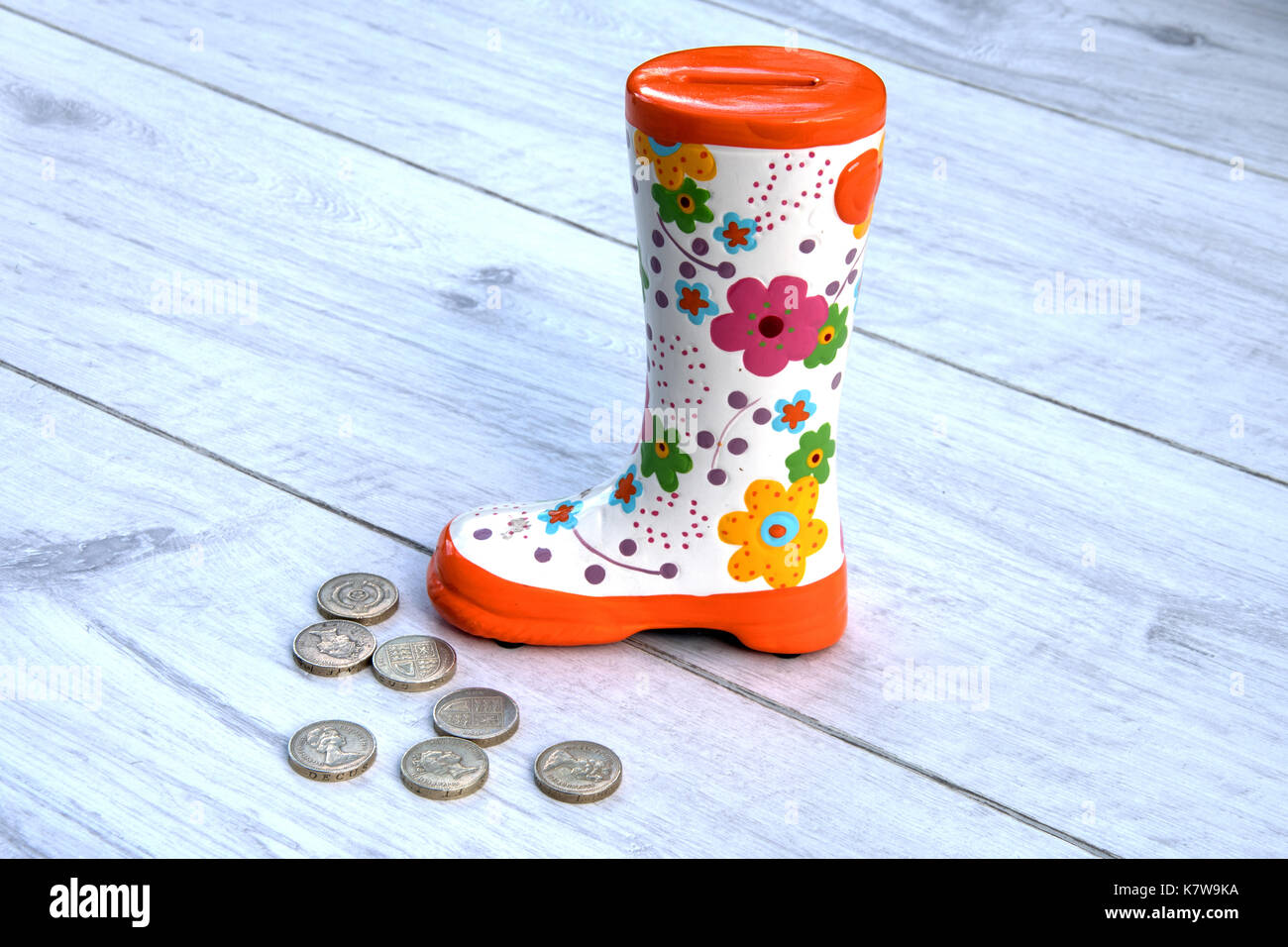 Decorative boot money box with old UK pound coins. Stock Photo