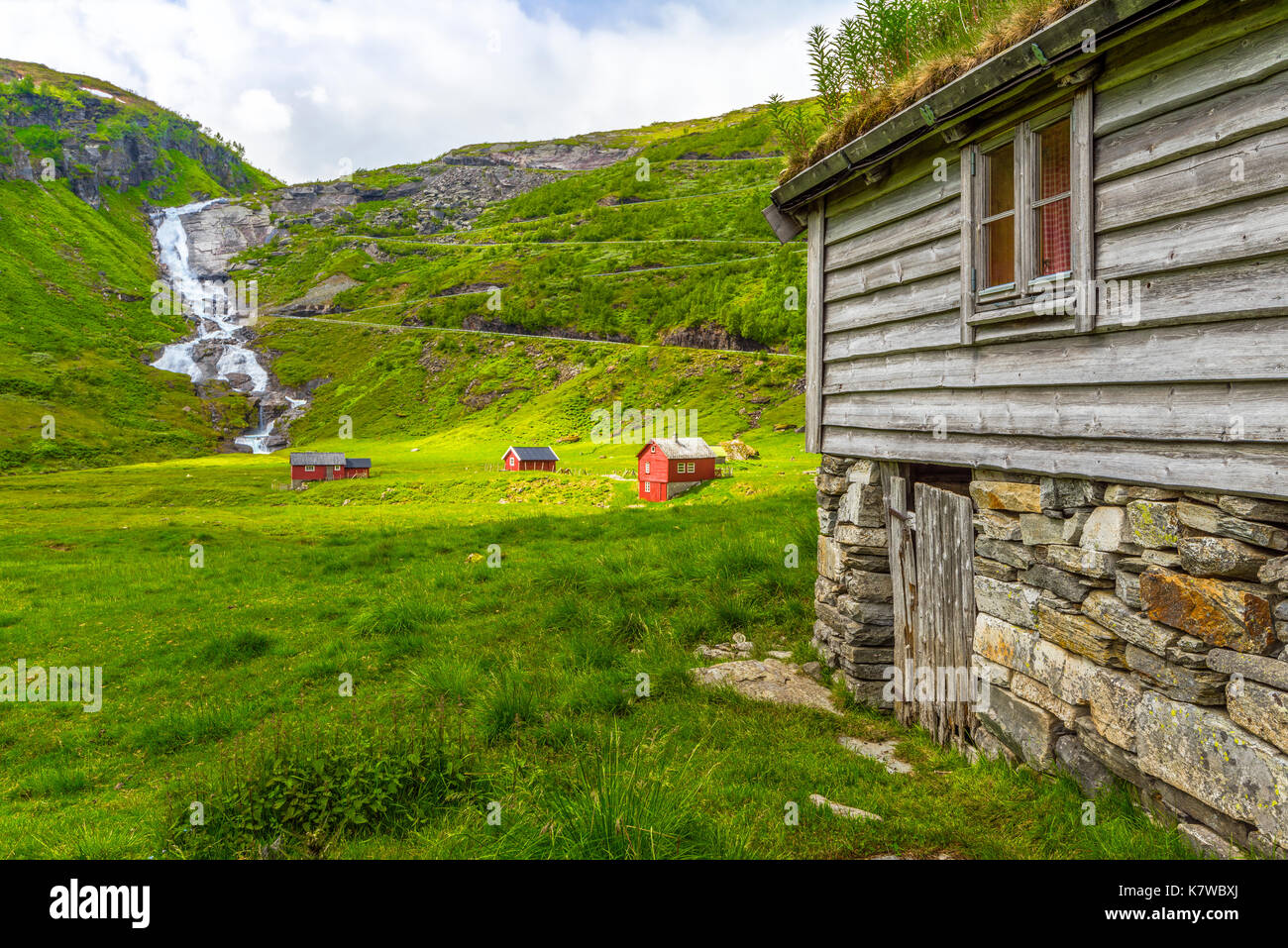 Waterfall Sendefossen, red wooden huts and the Serpentinveg near Myrkdalen, Vikafjell region, Norway, Scandinavia Stock Photo