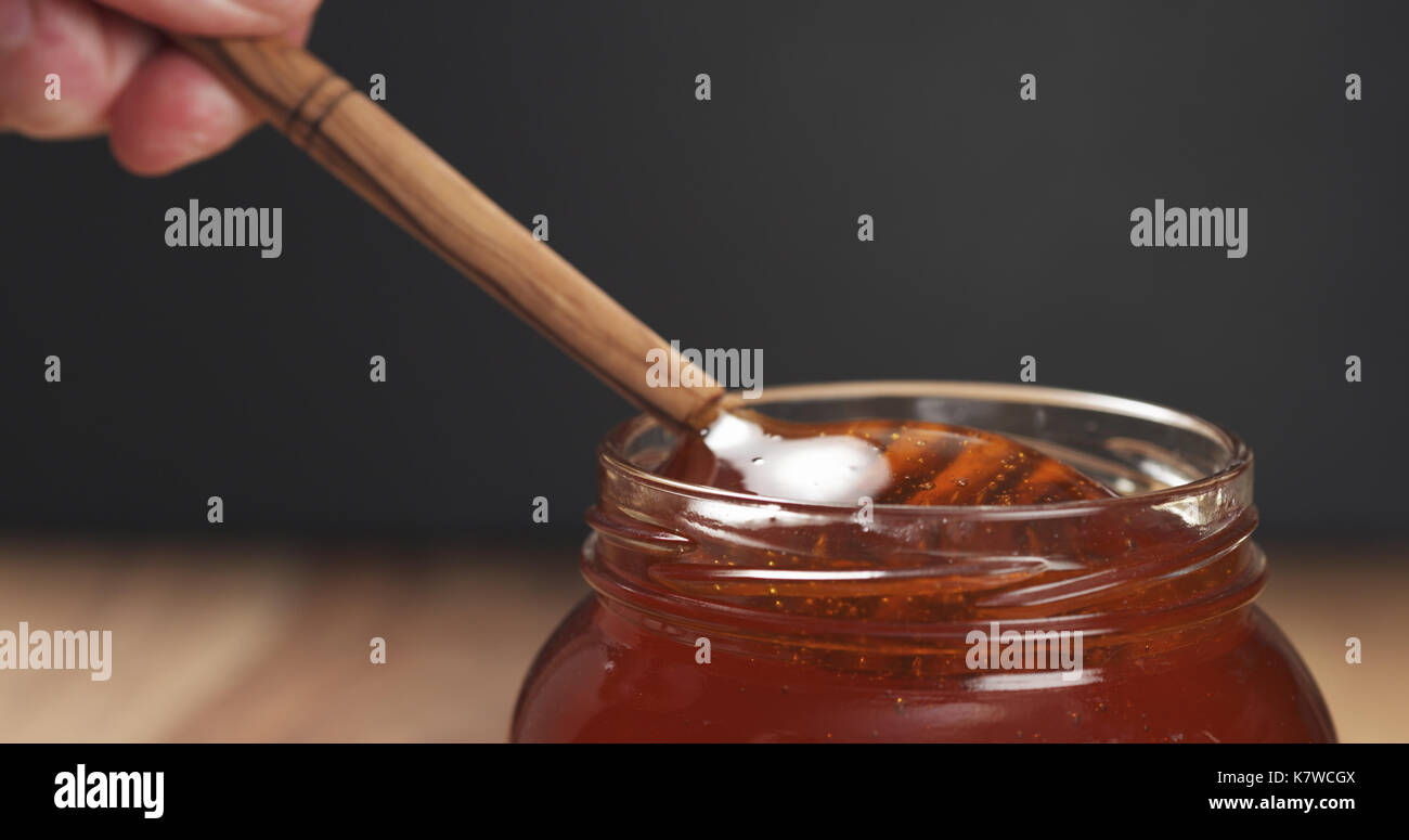 dipper in glass jar full of honey Stock Photo