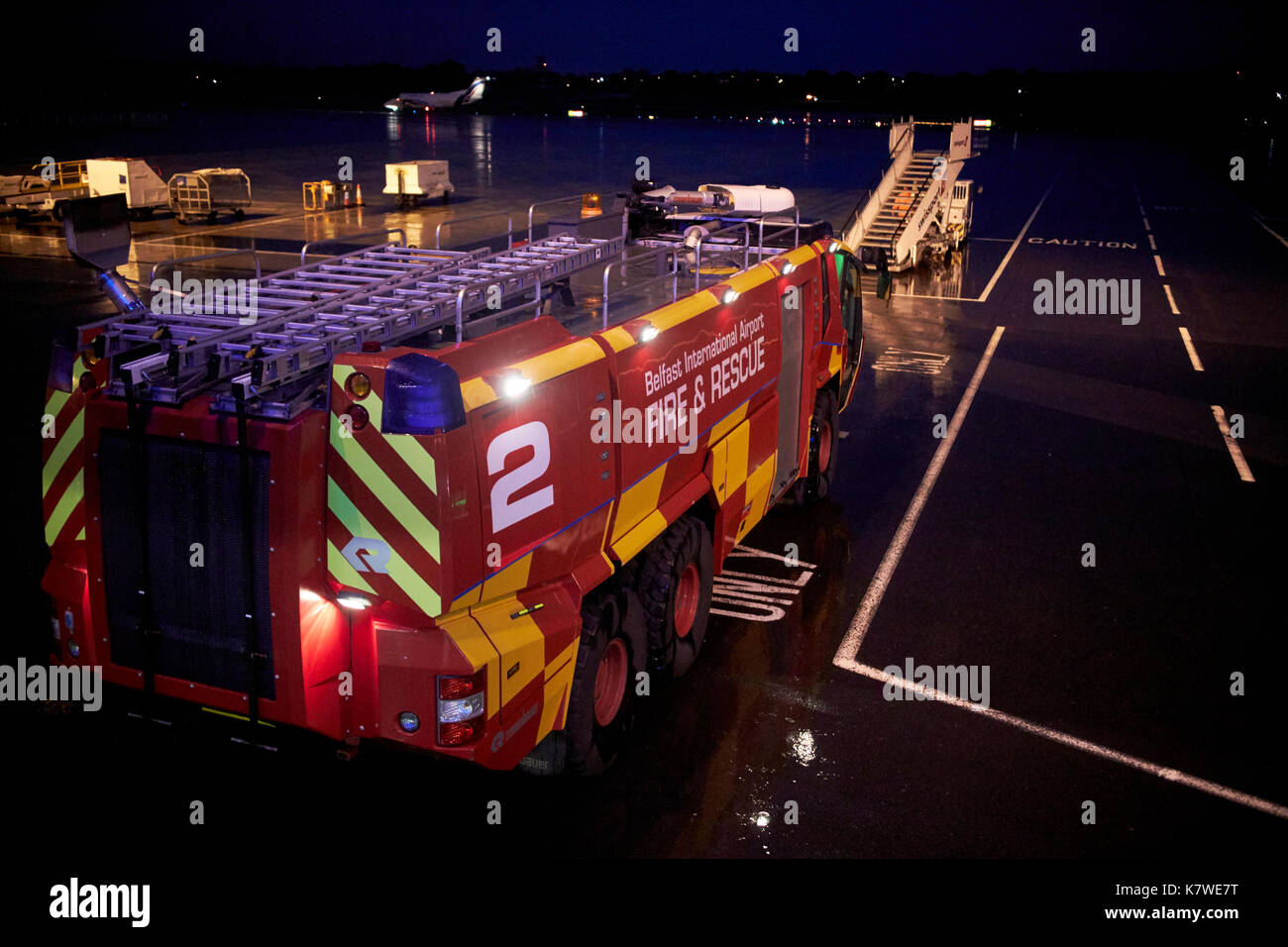 Belfast International airport fire and rescue vehicle waiting on stand at night in the rain Stock Photo