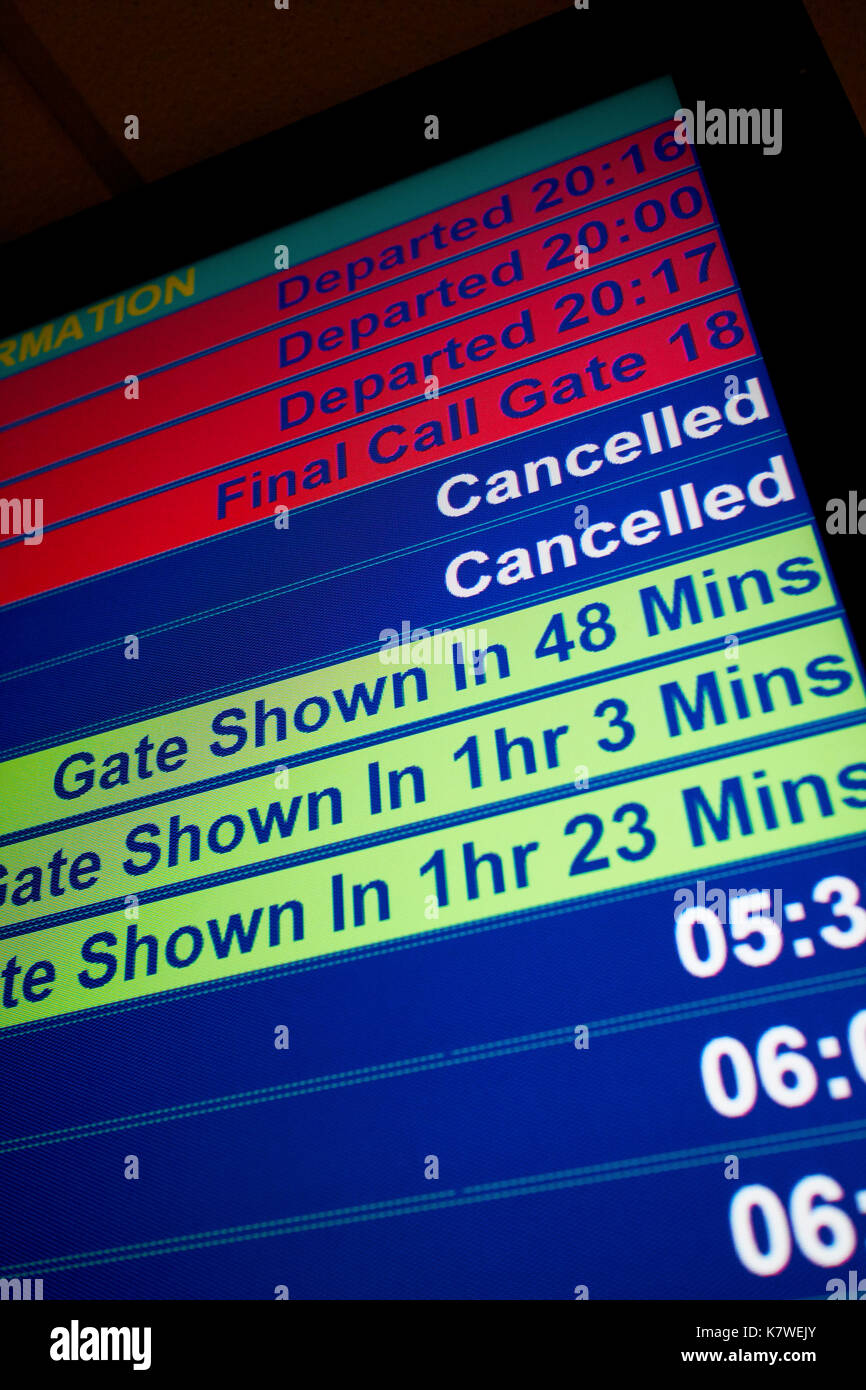 airport flight information screen showing last calls cancelled flights and gate information Stock Photo