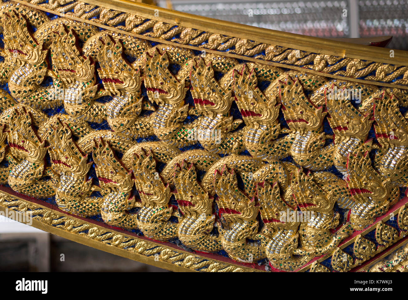 Royal Barge Anechatbhuchong is carved and gilded in pattern of small nagas. The hull is painted pink outside and red inside. Stock Photo