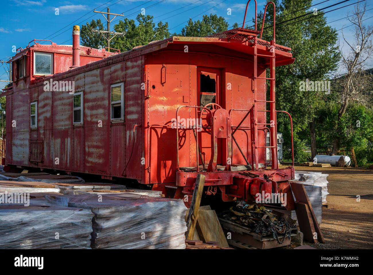 An old railroad caboose sitting in the parking lot of a business near