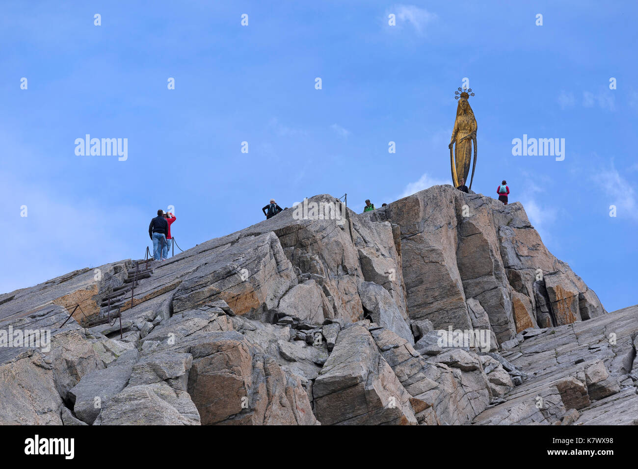 PASS MORO NEAR MACUGNAGA, ITALY - JULY 2017; Hikers walking towards the Madonna Delle Nevi statue. Stock Photo