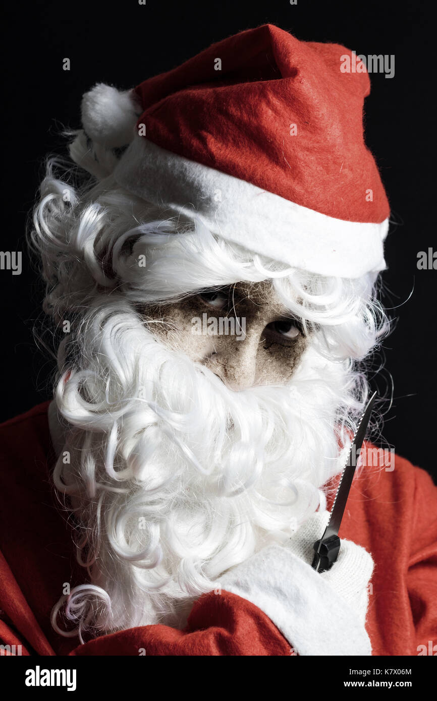 portrait of spooky looking santa claus with knife in hand Stock Photo