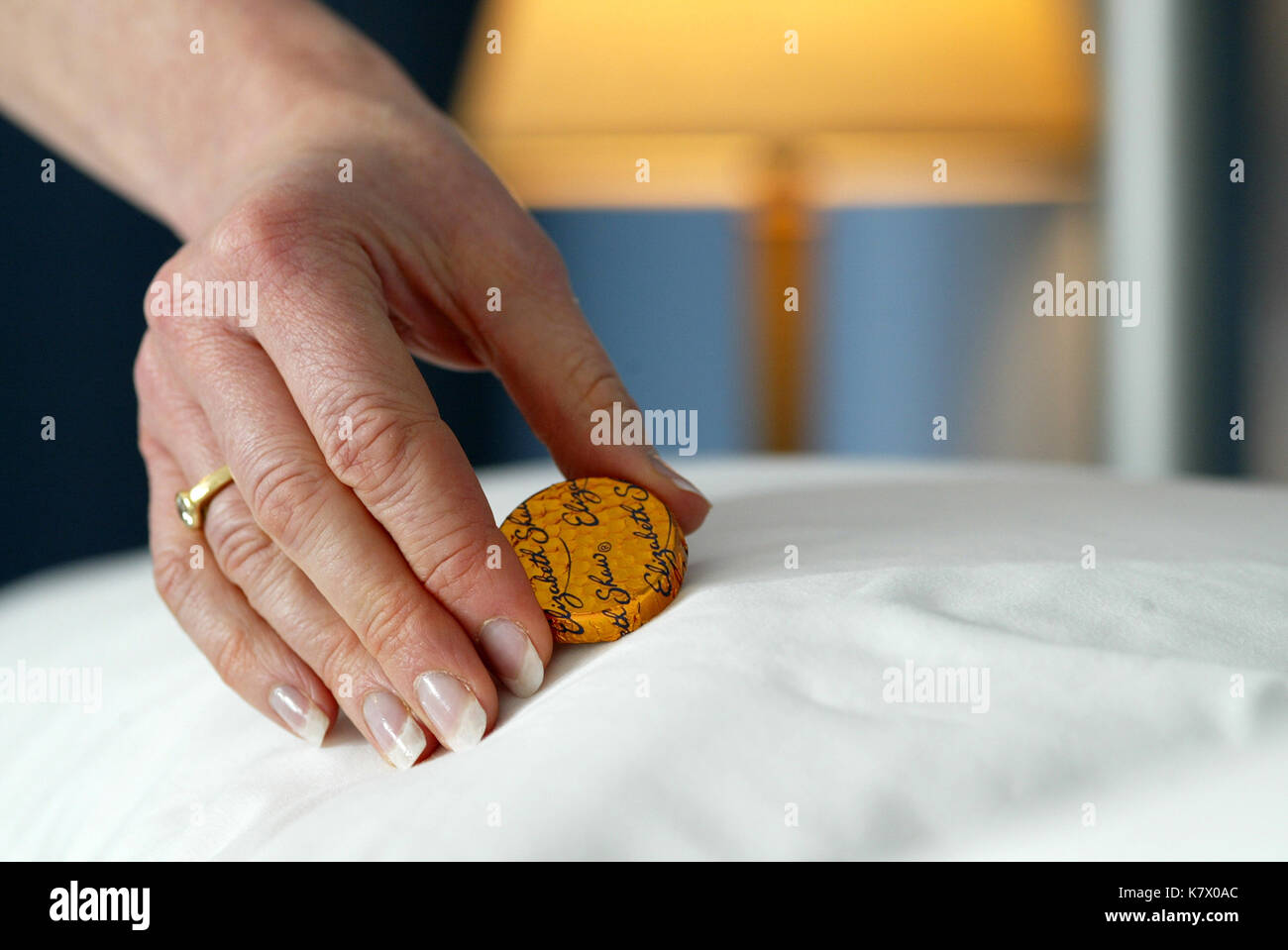 chocolate mint being placed on pillow in luxury hotel Stock Photo Alamy